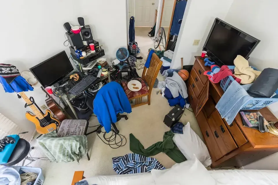 An empty bedroom with a ceiling fan and two windows.