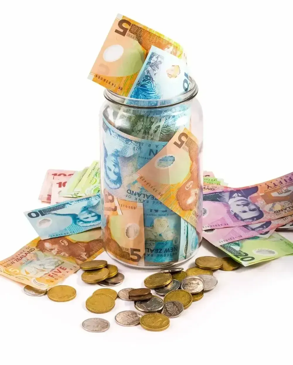 Jar of NZ banknotes with coins scattered around.