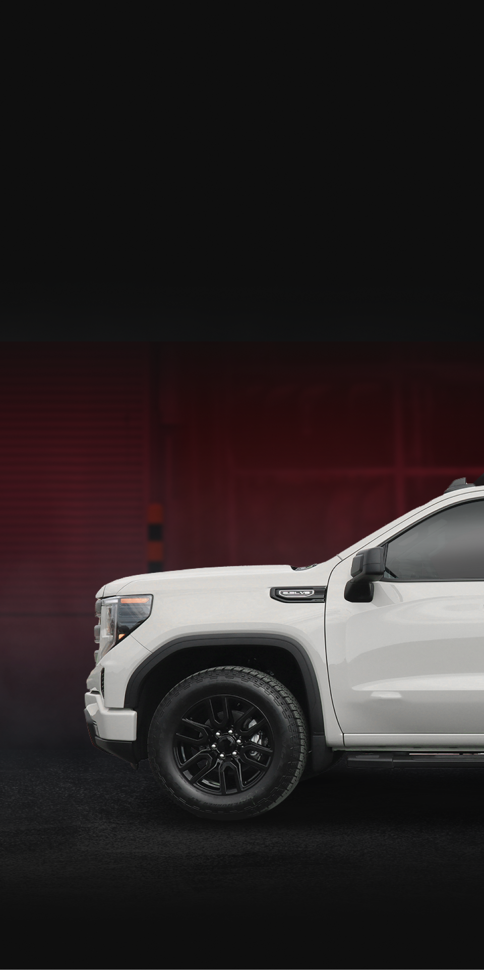 Black Mercedes-Benz sedan parked in front of a garage with a large red logo. | Gravity Service Center