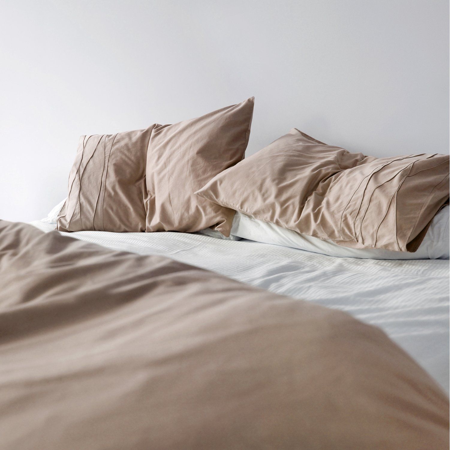 Stack of beige folded towels on a white background