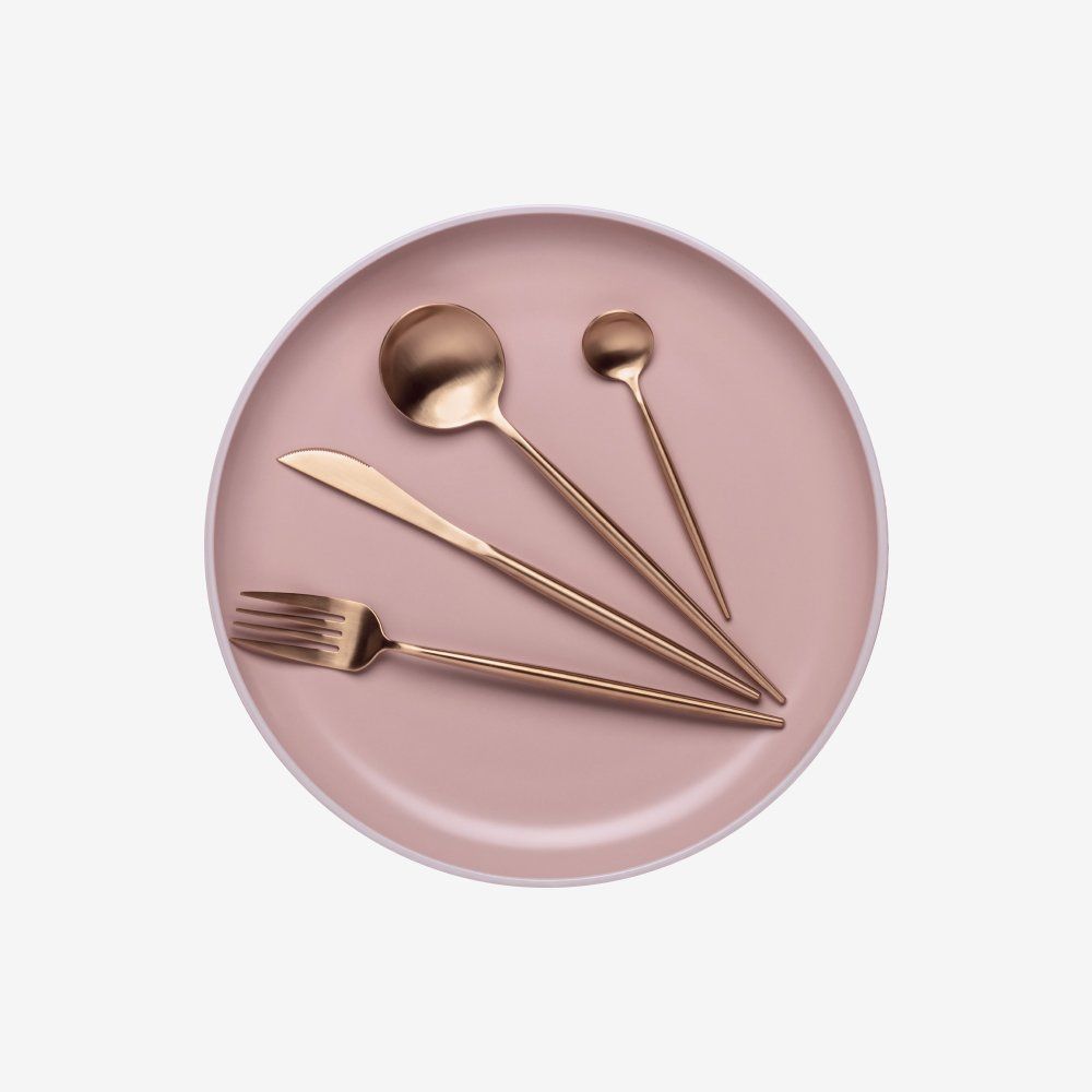 Four rose-gold utensils—spoon, fork, knife, and round spoon—on a white background