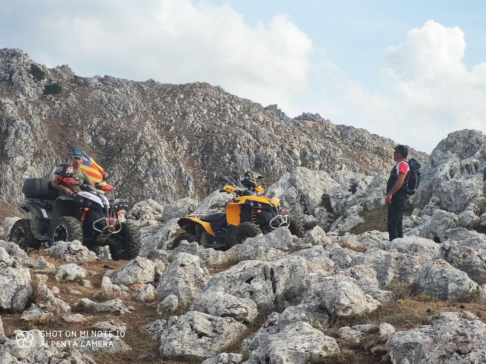 Due quad e una persona su un terreno roccioso.