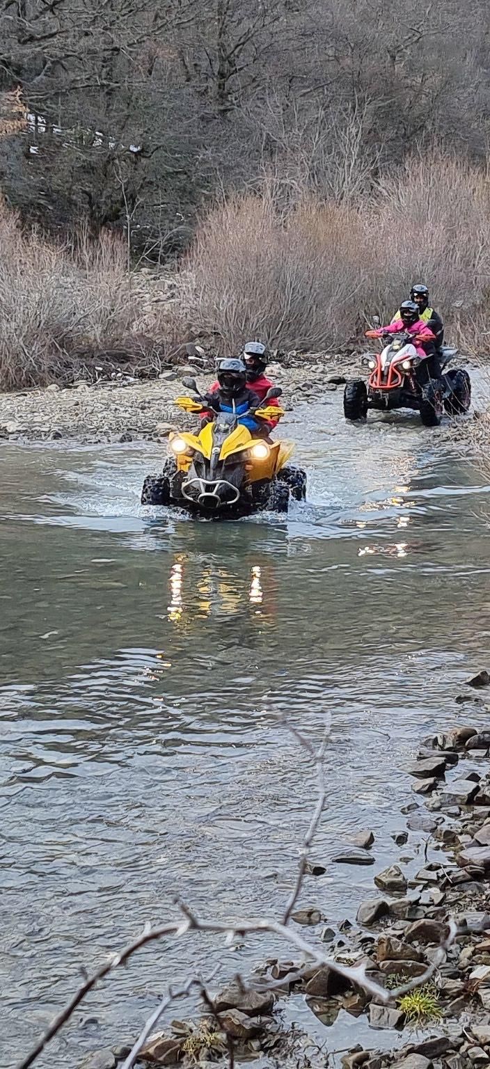 Due quad attraversano l'acqua, con i conducenti che indossano il casco.