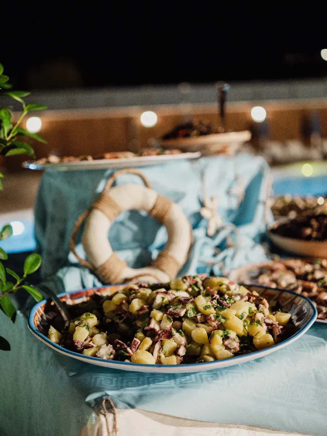 Insalata di patate su un piatto decorativo in un buffet all'aperto a tema nautico.