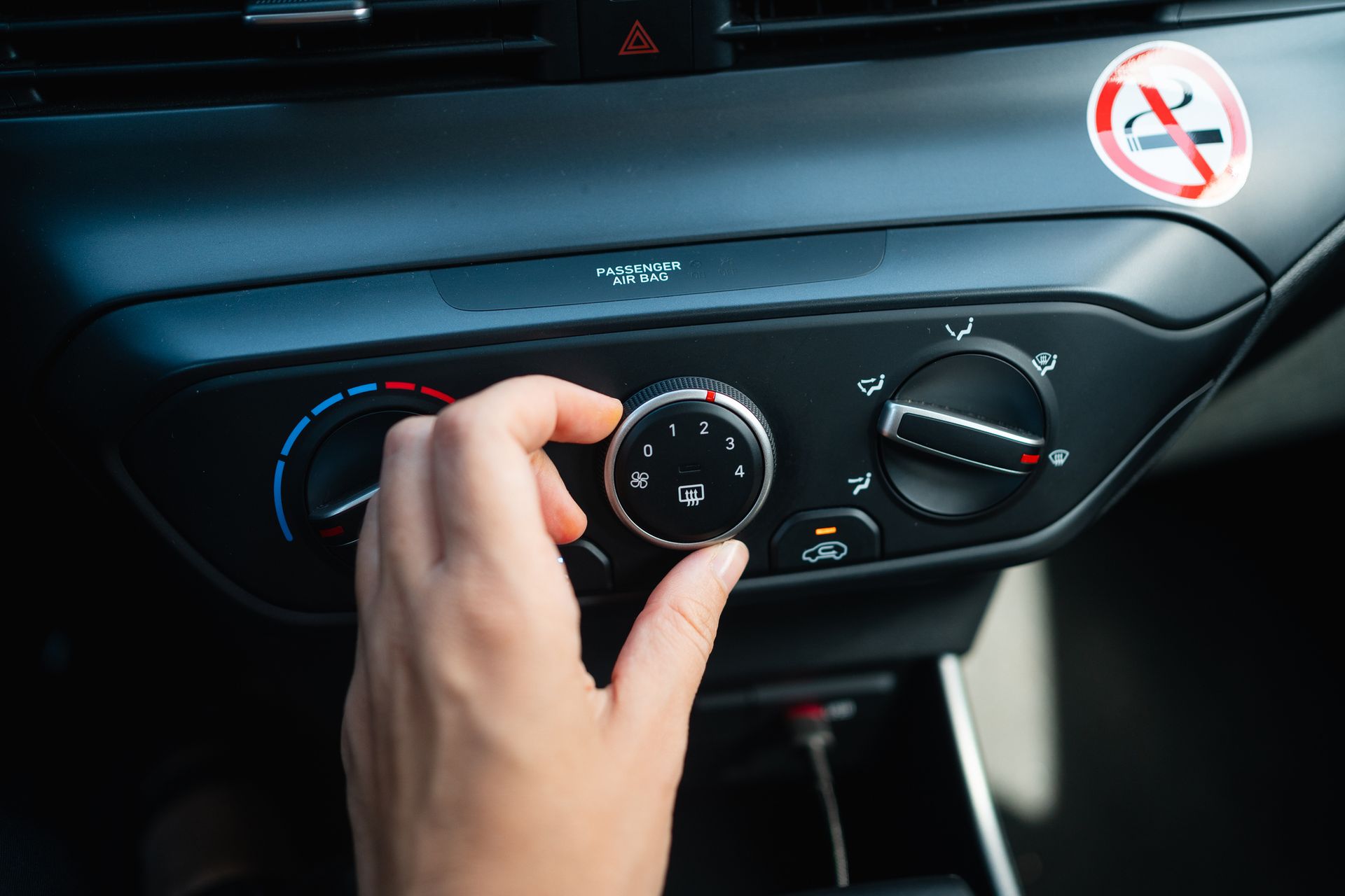Driver adjusting dashboard AC controls inside car, illustrating car ac repair and system check.