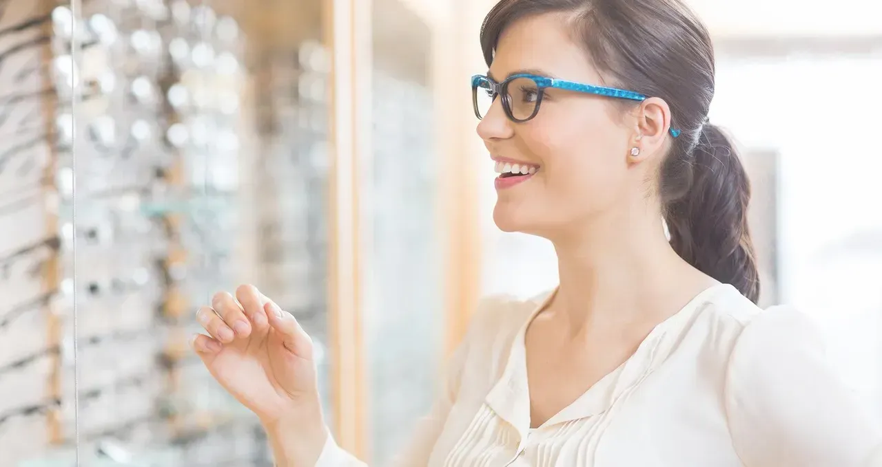 A Woman Is Wearing Glasses In An Optical Shop — Central Coast Eyecare In Gosford, NSW