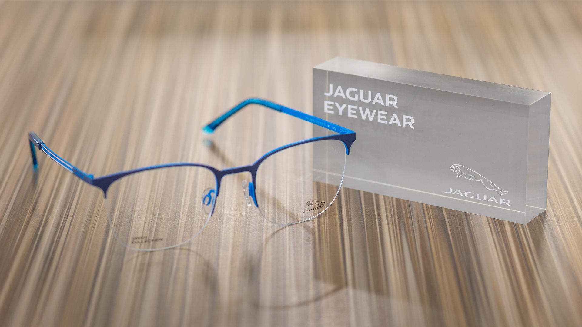 A Pair Of Glasses Is Sitting On A Wooden Table Next To A Box — Central Coast Eyecare In Gosford, NSW