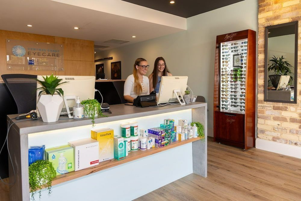 Two Women Are Standing At A Counter In A Store — Central Coast Eyecare In Budgewoi, NSW