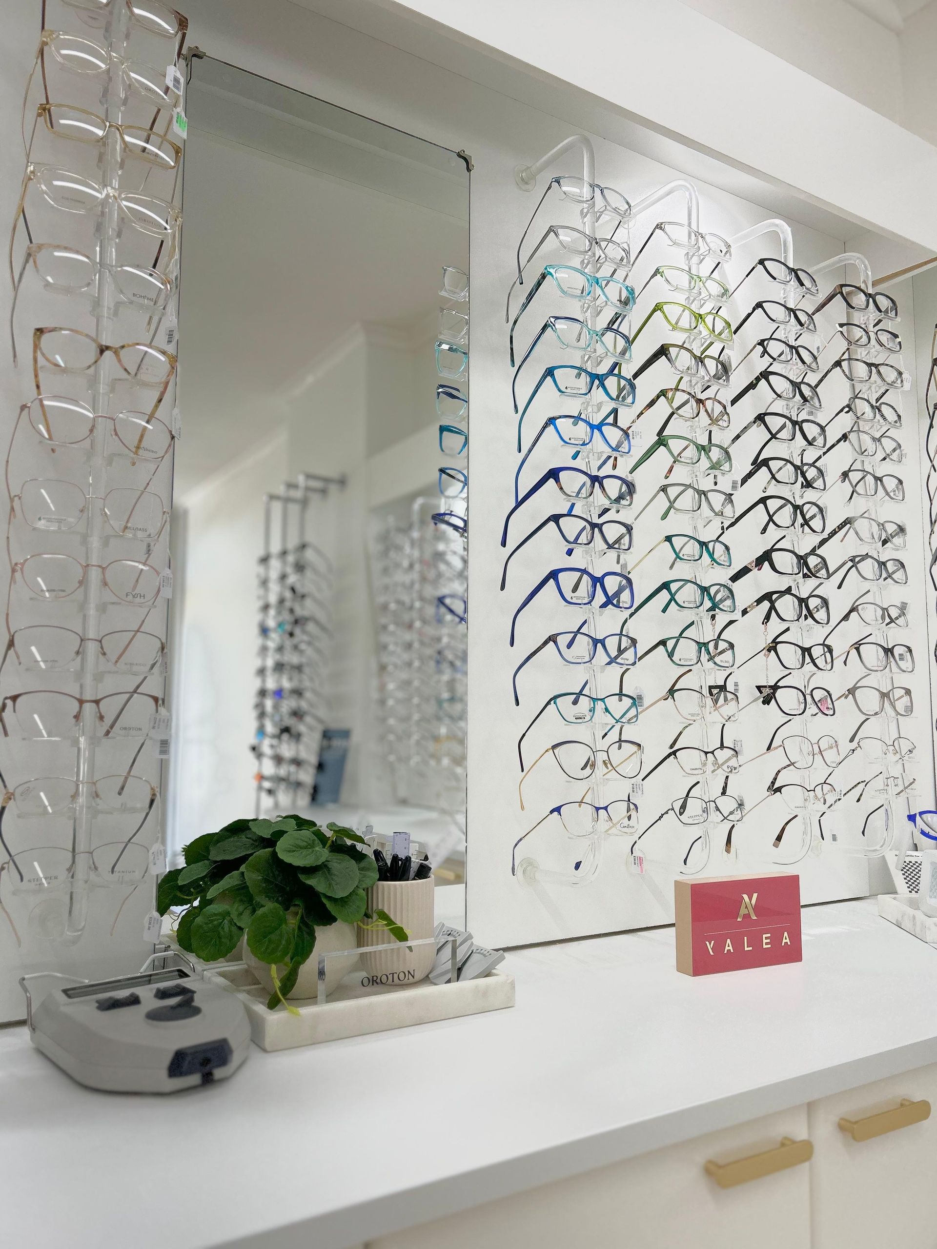A Woman Is Standing In Front Of A Mirror In An Optical Shop — Central Coast Eyecare In Budgewoi, NSW