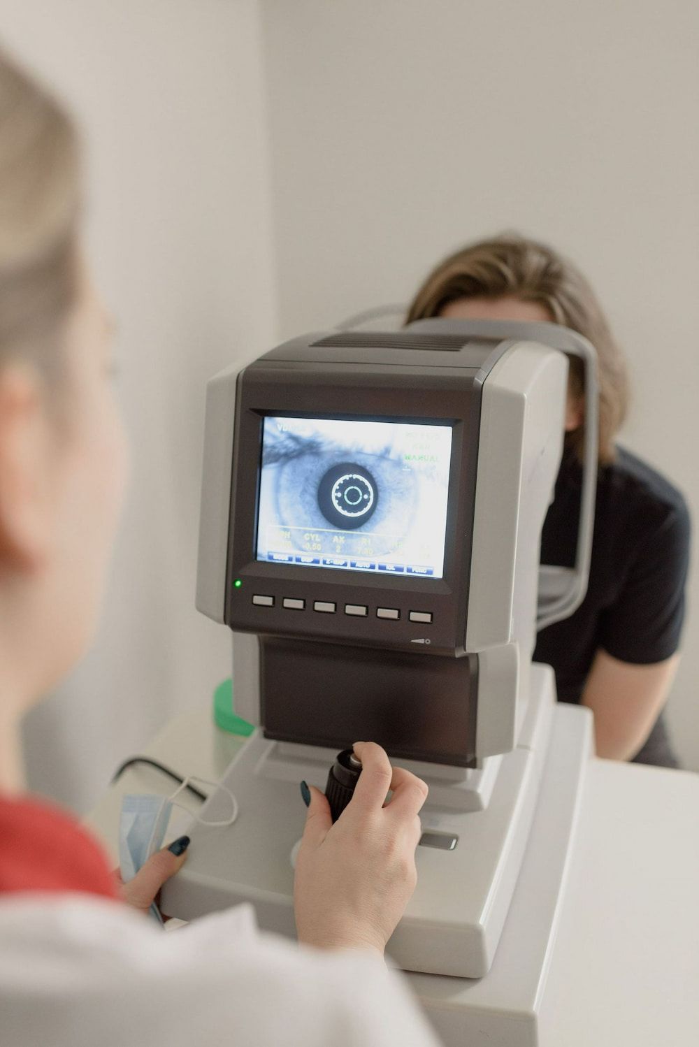 A Woman Is Getting Her Eyes Checked By An Ophthalmologist — Central Coast Eyecare In Erina, NSW