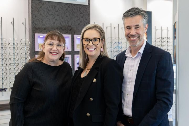 A Man And Two Women Are Posing For A Picture In An Optical Shop — Central Coast Eyecare In Gosford, NSW