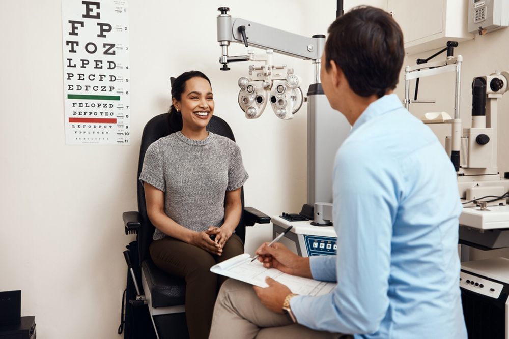 Ophthalmologist Discussing With The Patient While Holding A Paper — Central Coast Eyecare In Gosford, NSW