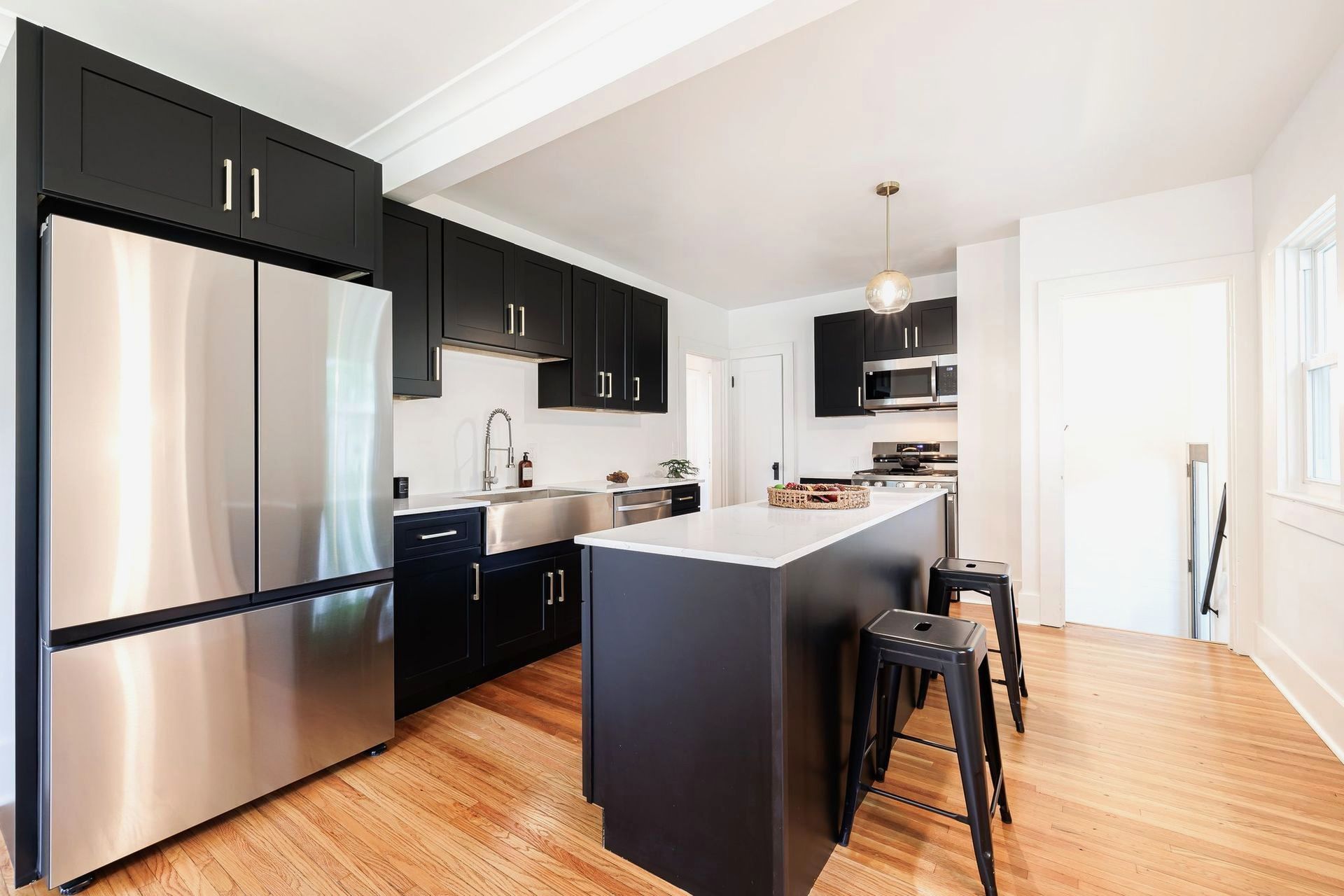 A kitchen with black cabinets and stainless steel appliances