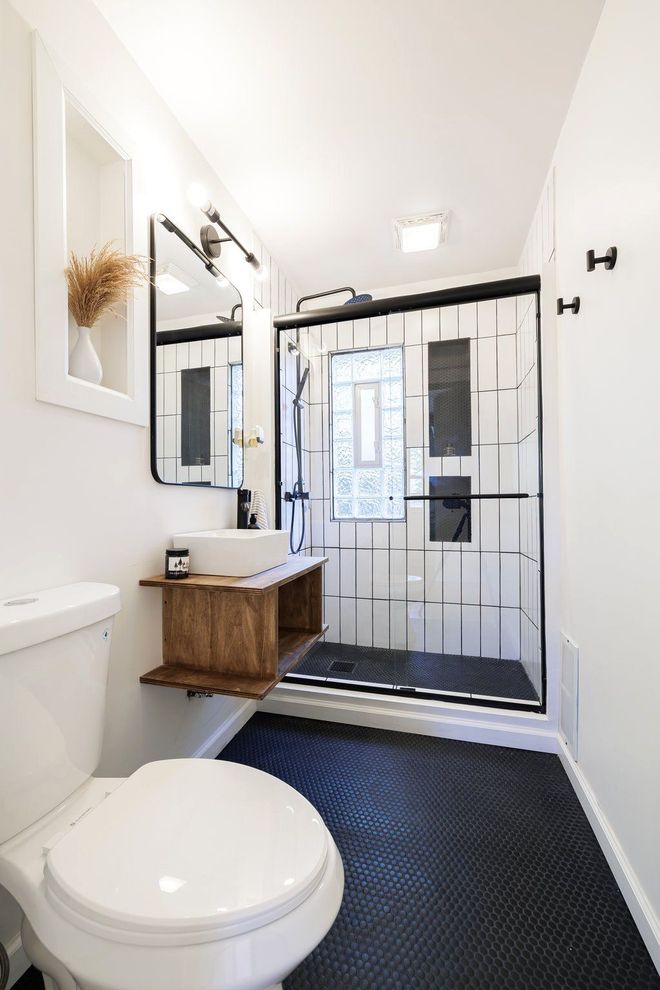 A bathroom with a toilet , sink and shower.