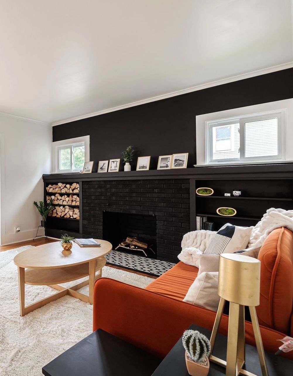 A living room with a fireplace , couch , table and lamp.