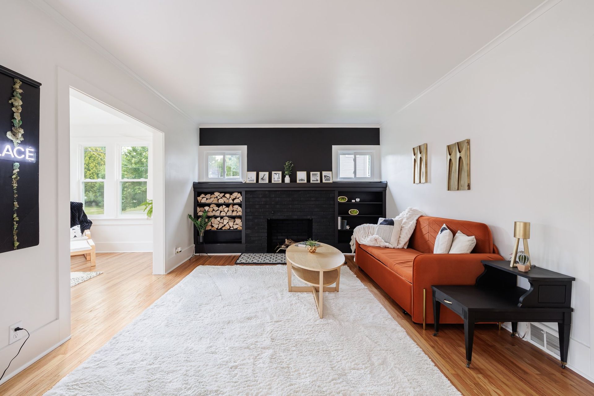 A living room with an orange couch and a fireplace