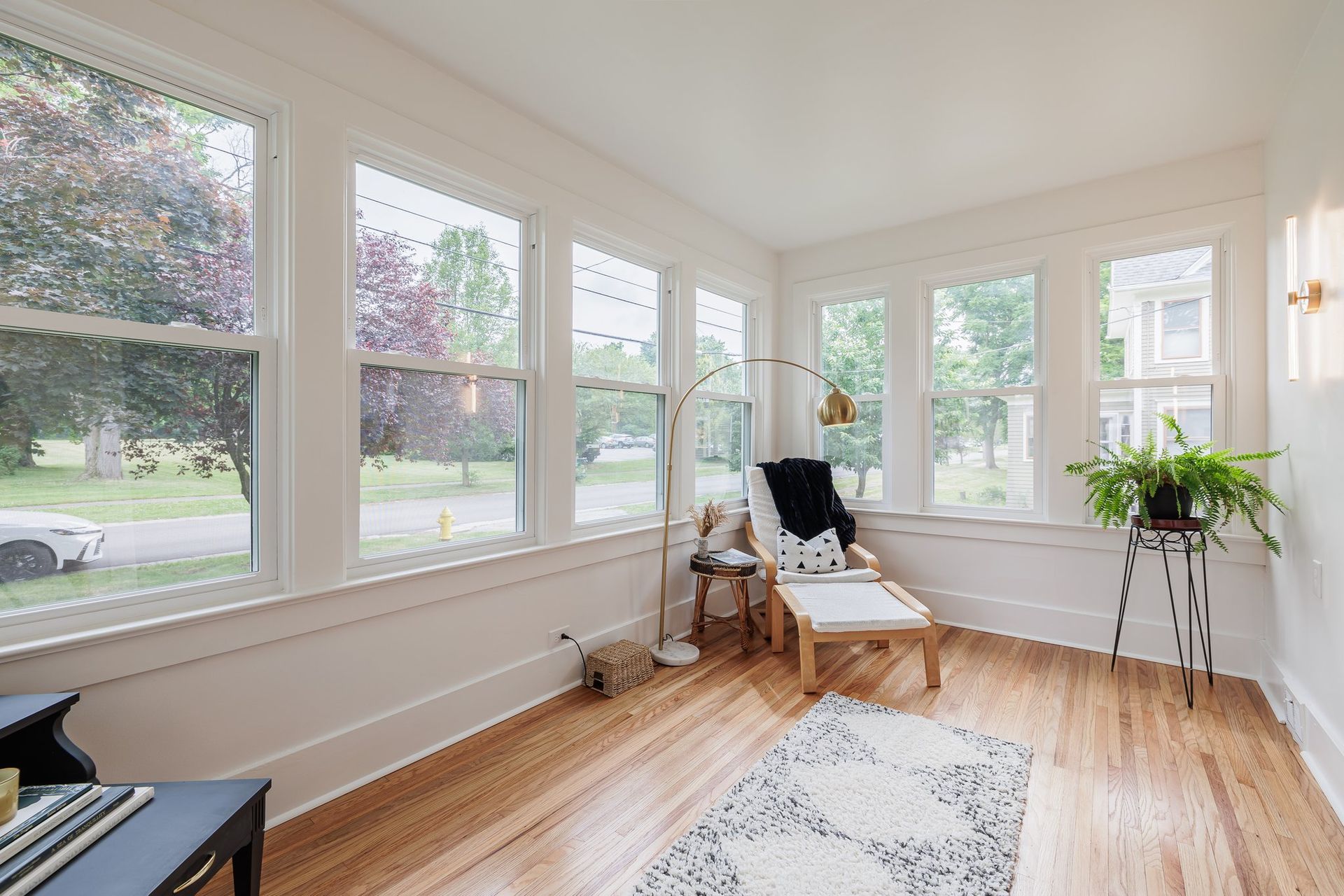 A living room with hardwood floors and lots of windows.