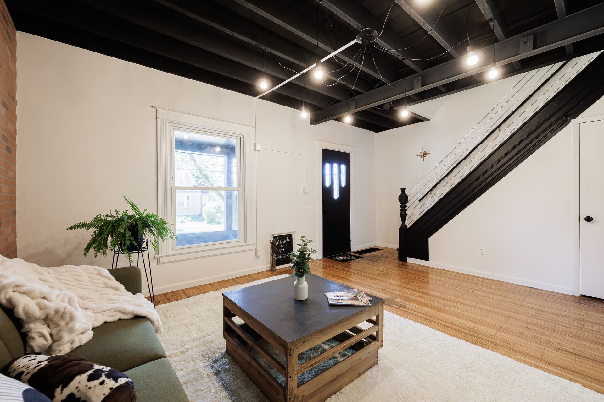 A living room with a couch , coffee table , and stairs.