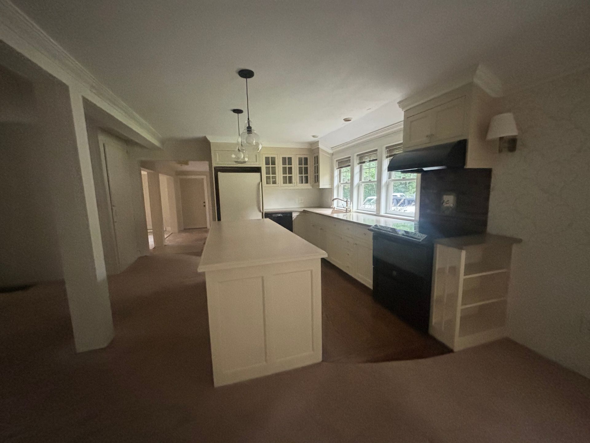 An empty living room with a fireplace and a ceiling fan.