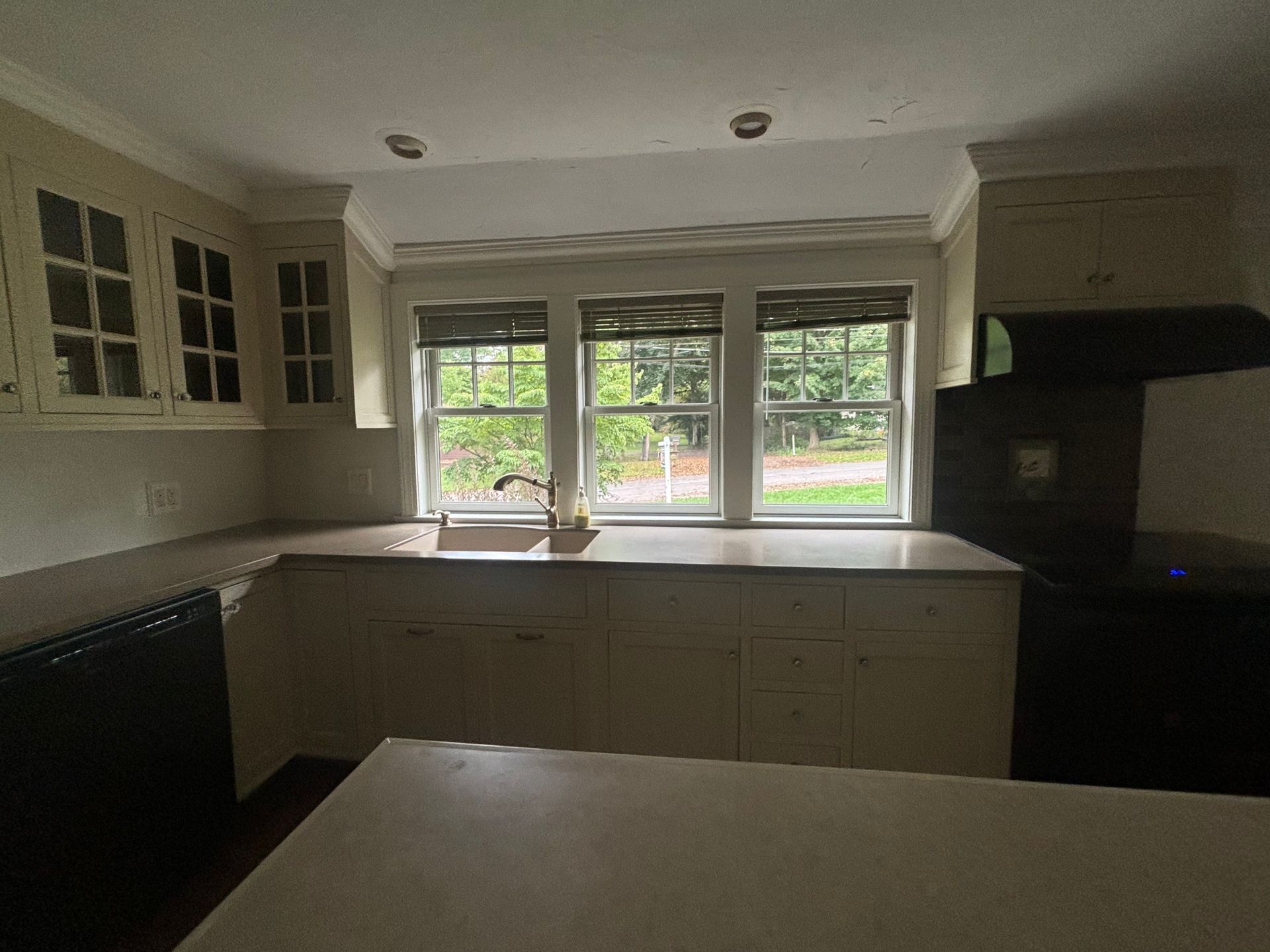 A kitchen with a black refrigerator and white cabinets