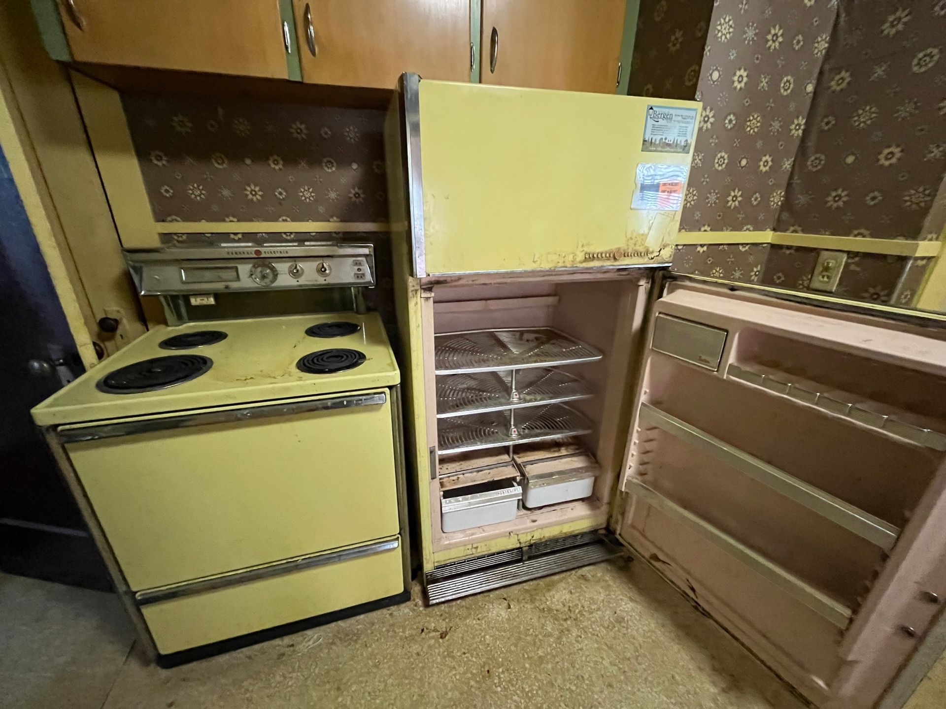 A kitchen with a yellow stove and a pink refrigerator