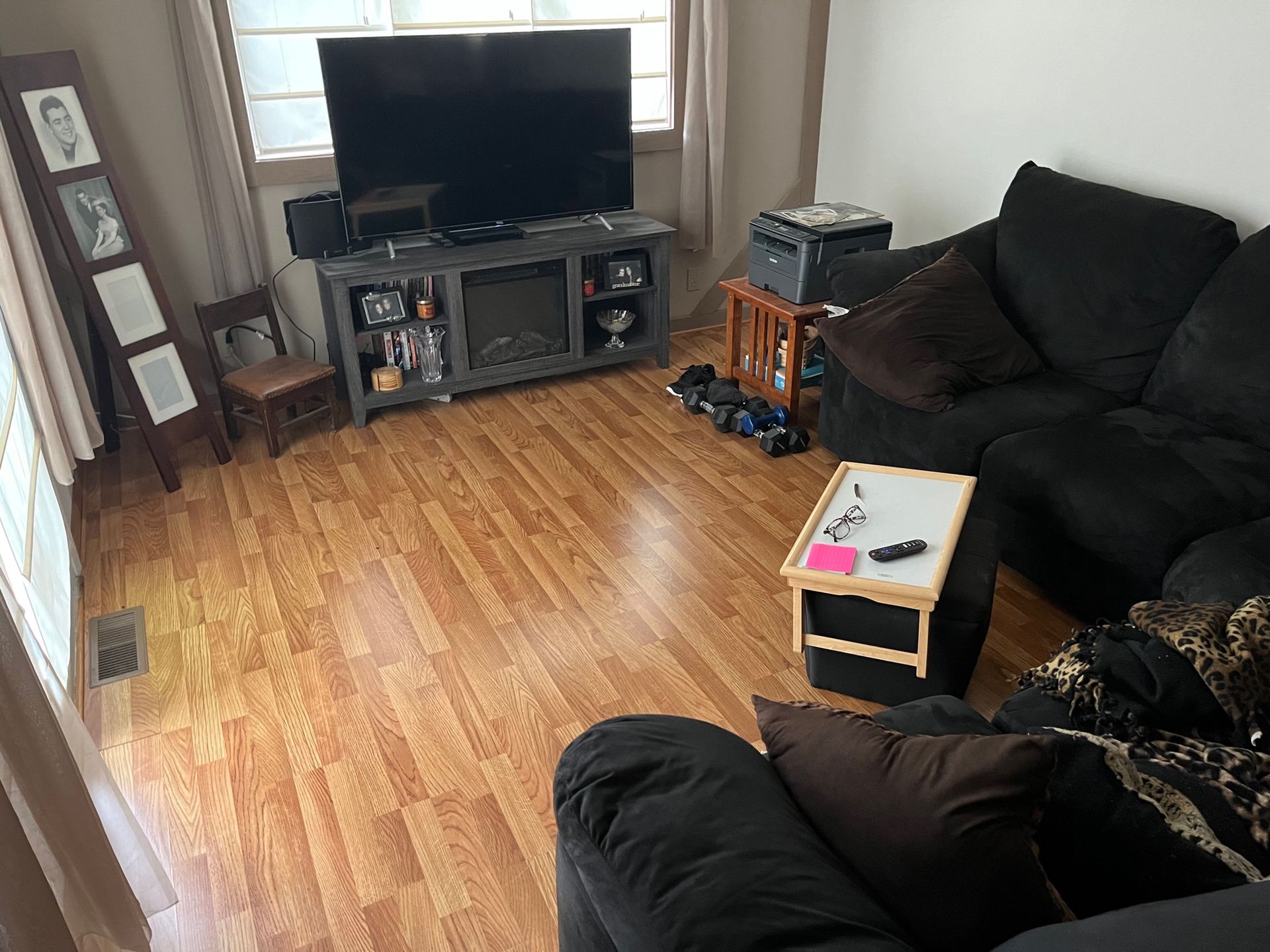 A living room with a couch , table , television and fireplace.