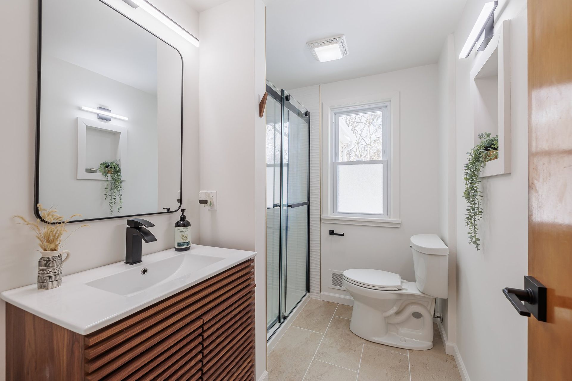 A bathroom with a toilet , sink and mirror.