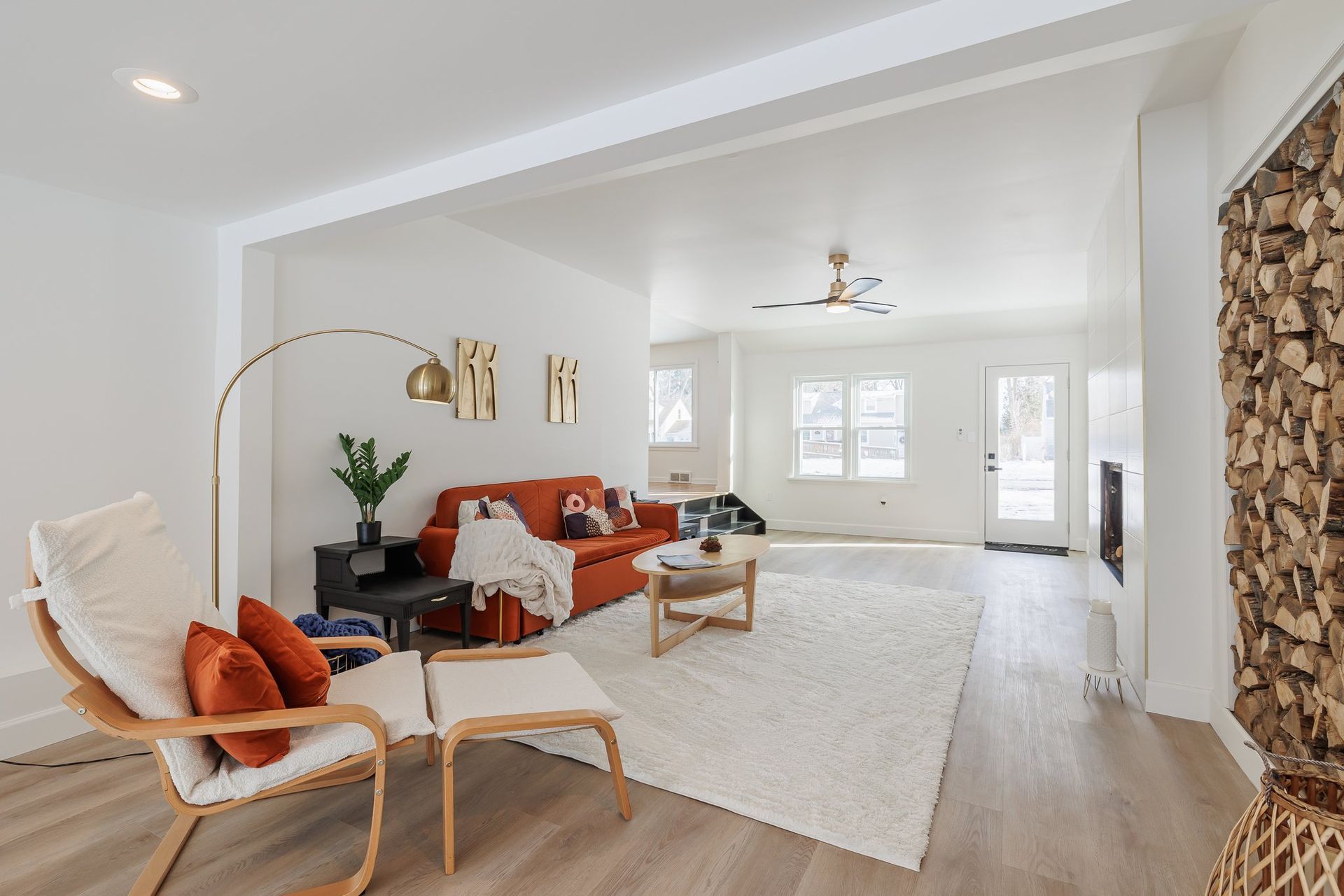 A living room with a couch , chair , coffee table and rug.