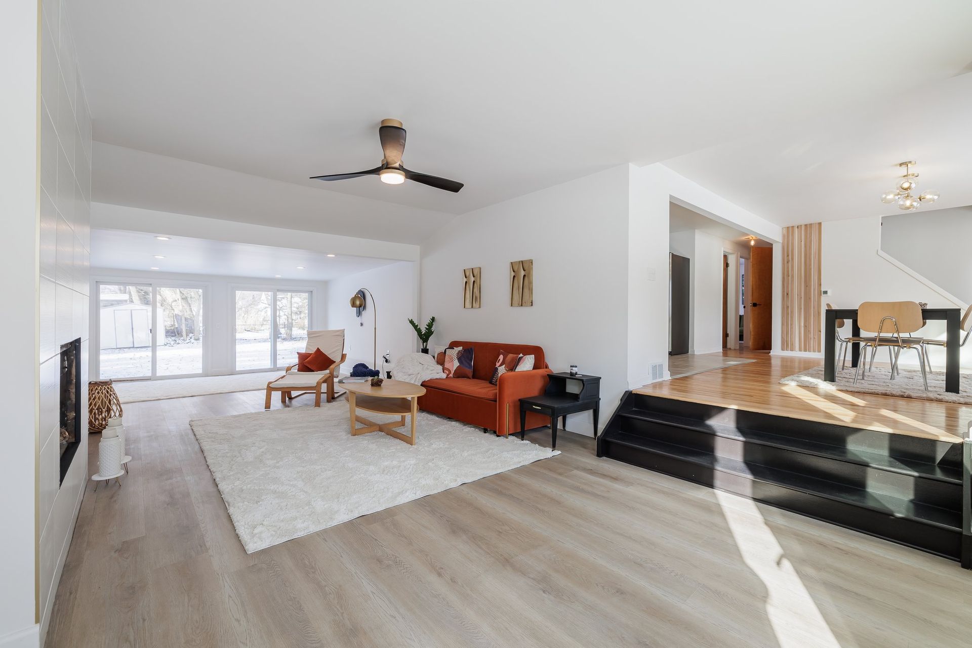 A living room with a red couch and a ceiling fan.