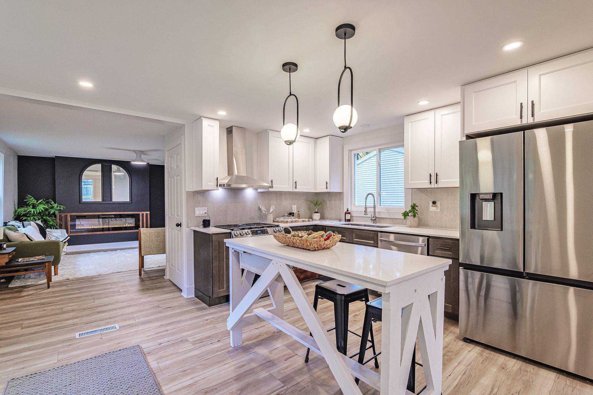 A living room with a dining table and chairs and a kitchen.