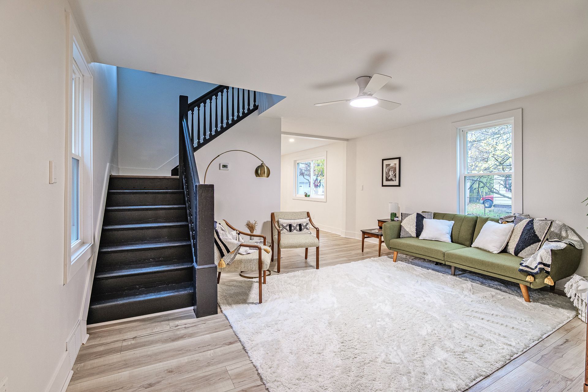 A living room with an orange couch and a fireplace