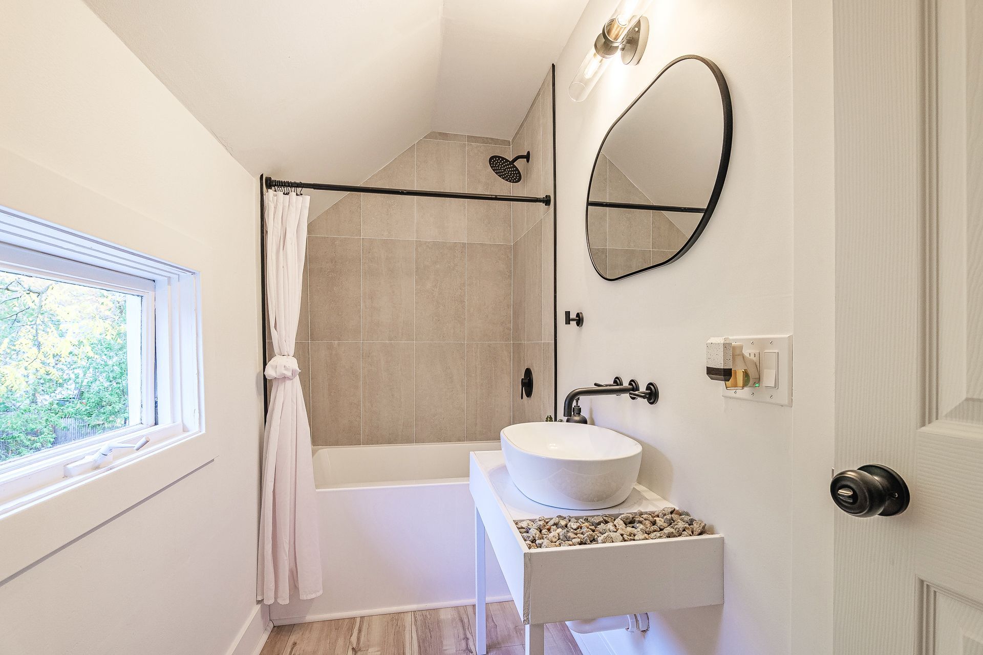 A bathroom with a sink , mirror , and walk in shower.