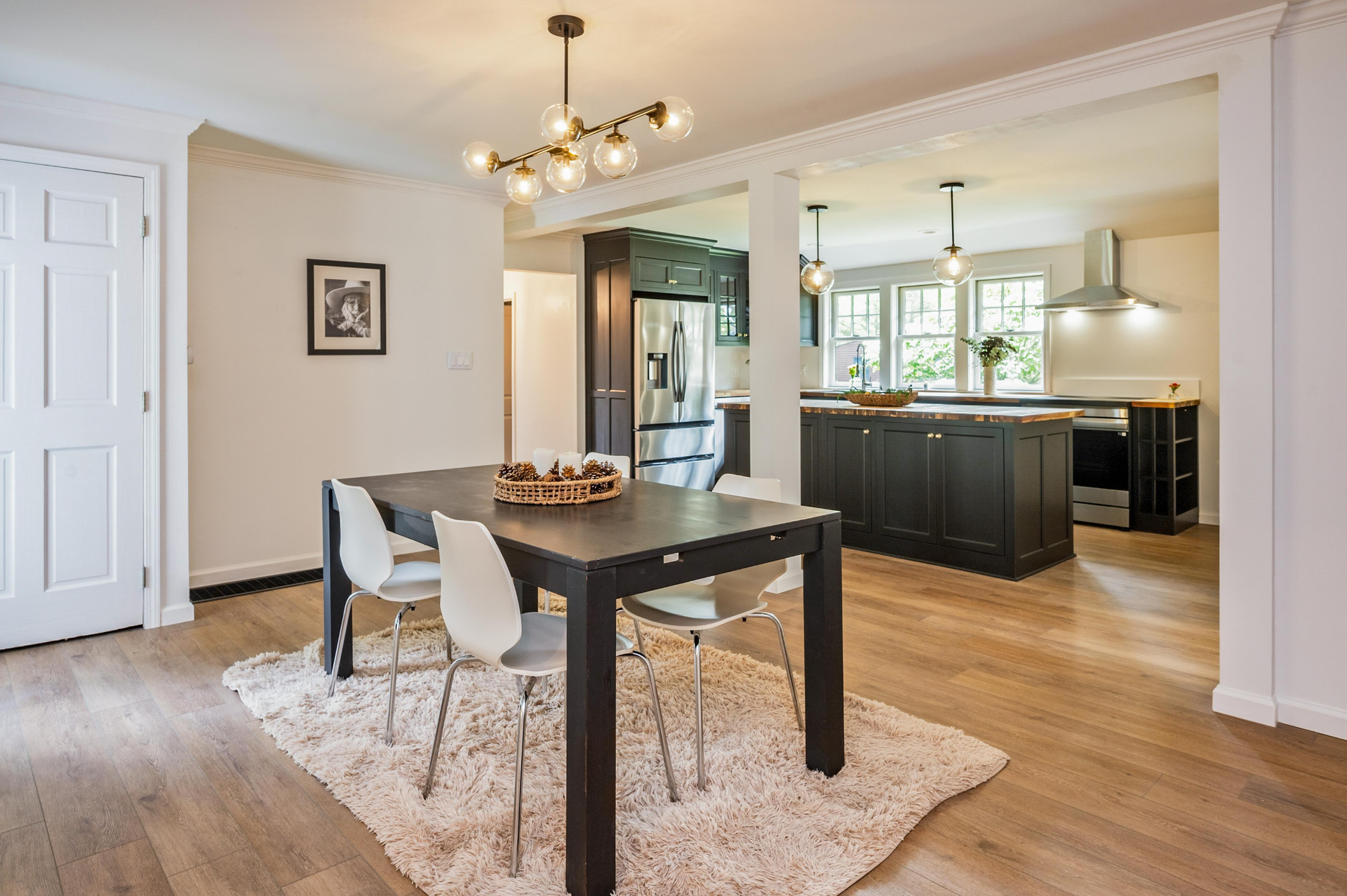 A dining room with a table and chairs and a rug.