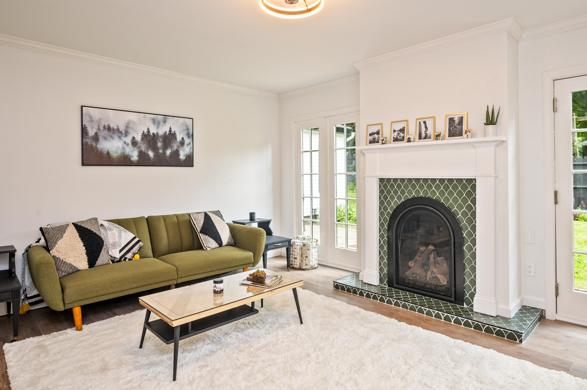 A living room with a green couch and a fireplace.