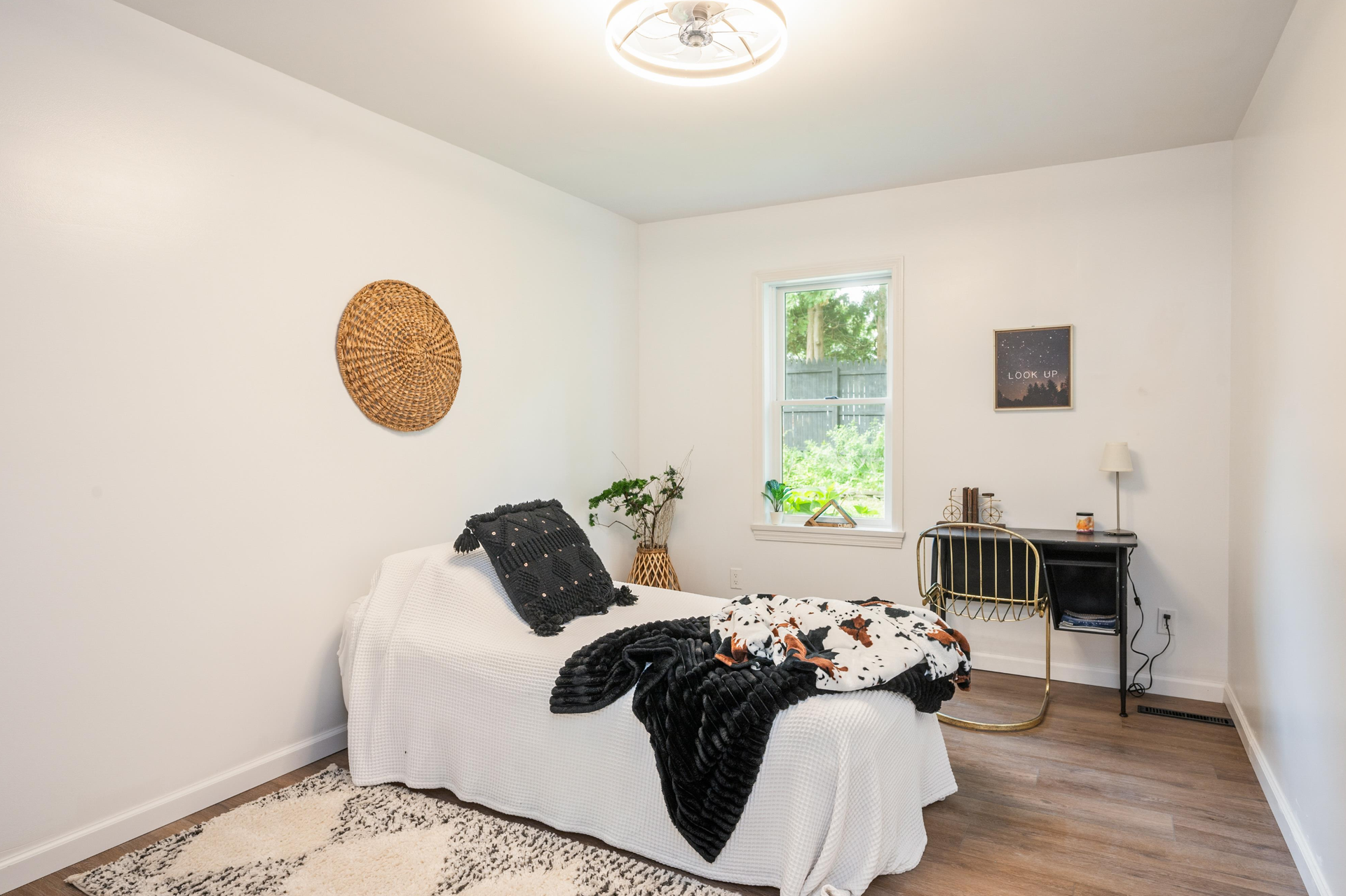 A bedroom with a bed , desk , and window.