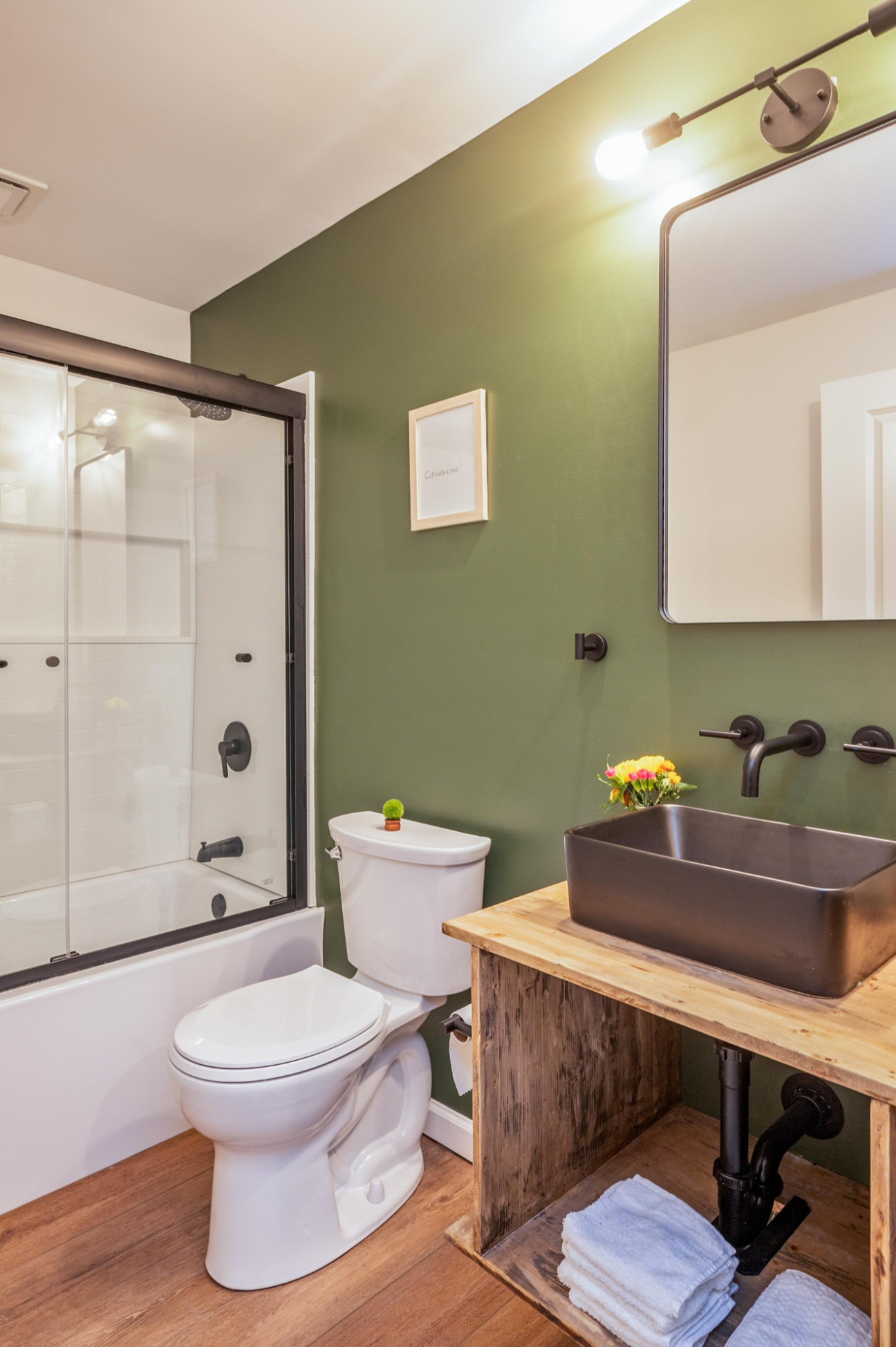 A bathroom with a toilet , sink and shower.