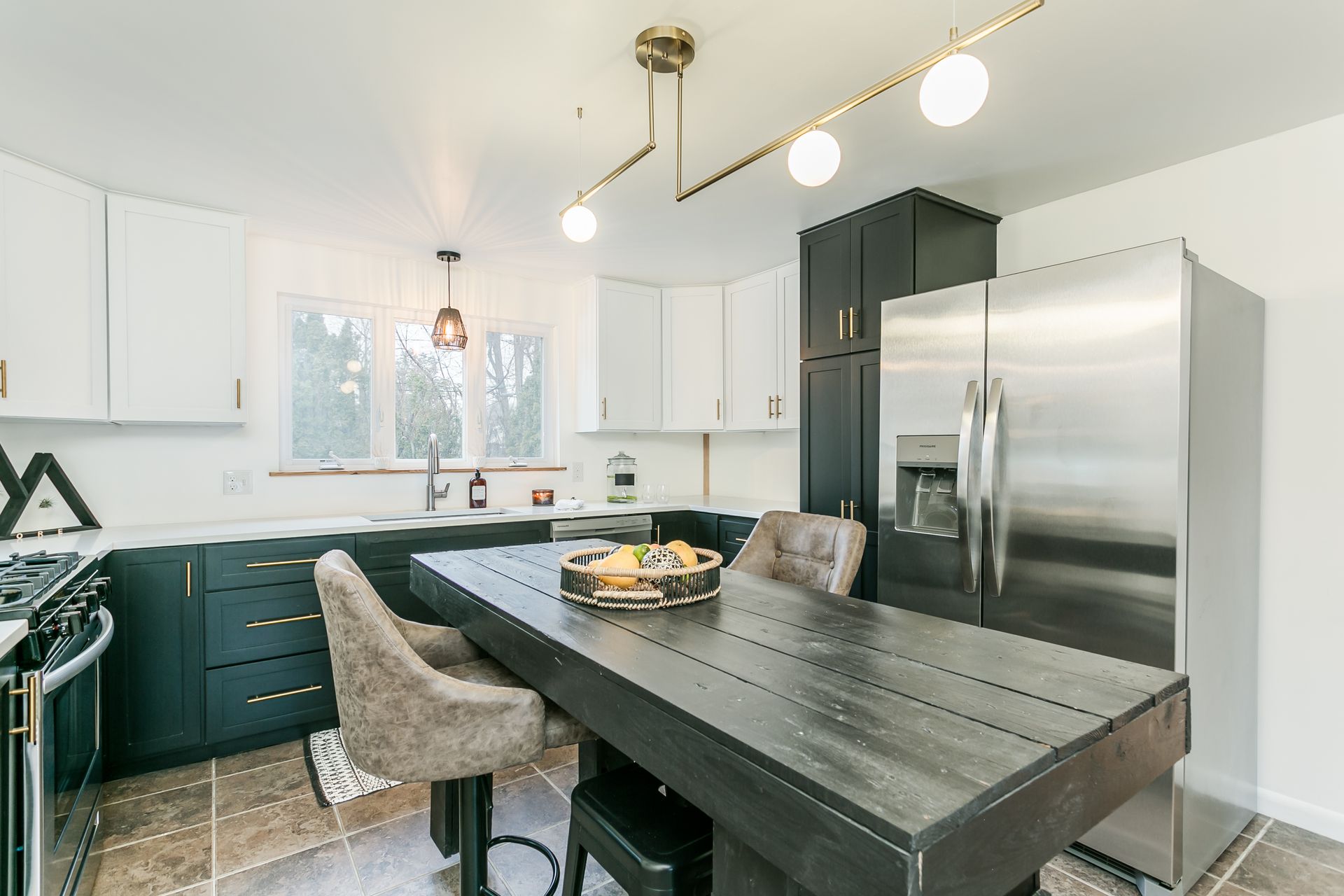 A kitchen with a table and chairs and a refrigerator.