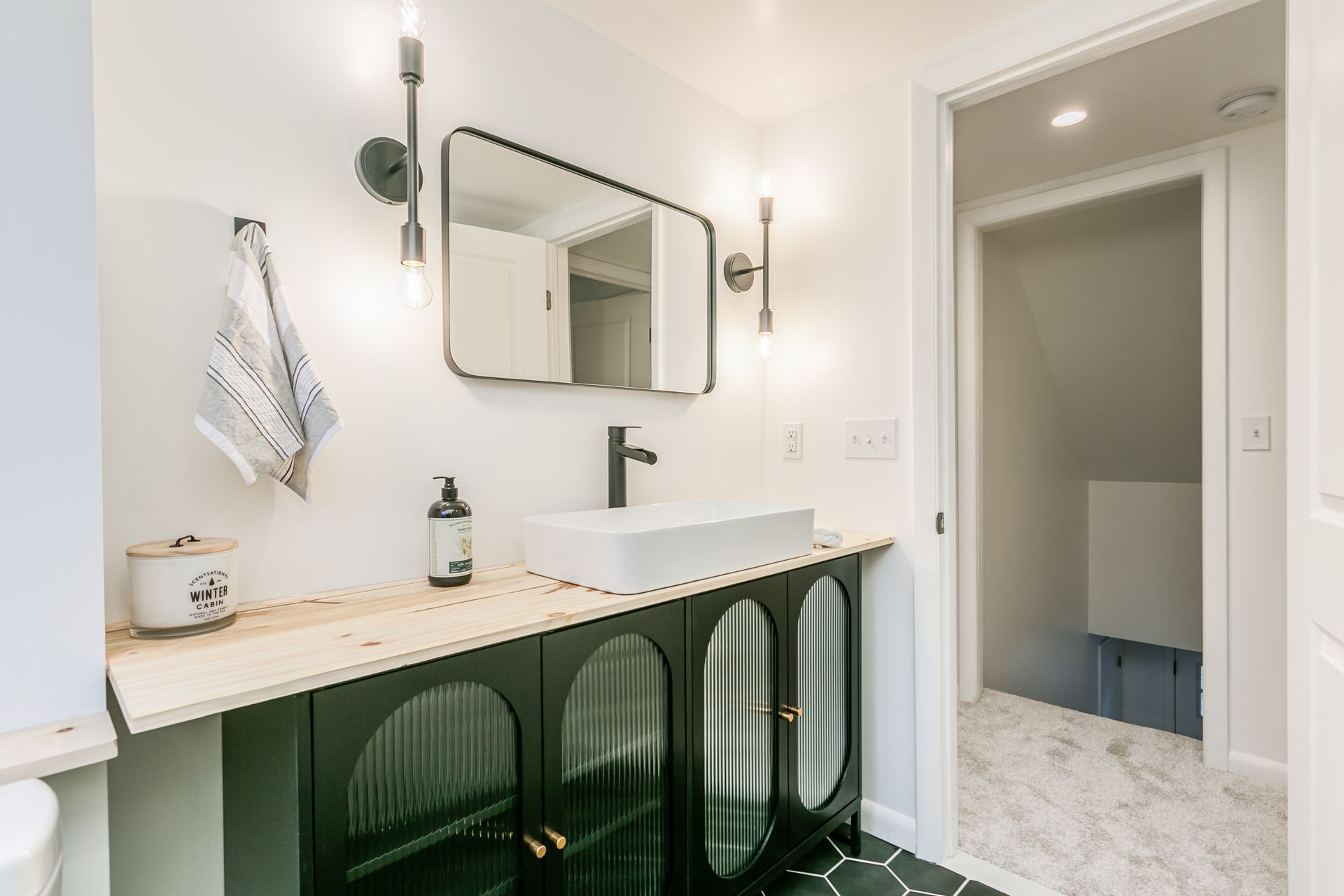 A bathroom with a sink , mirror and toilet.