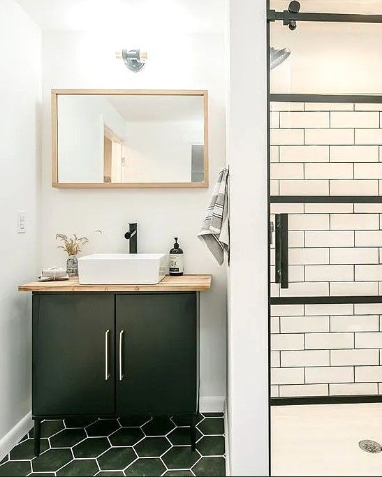 A bathroom with a sink , mirror , and shower.