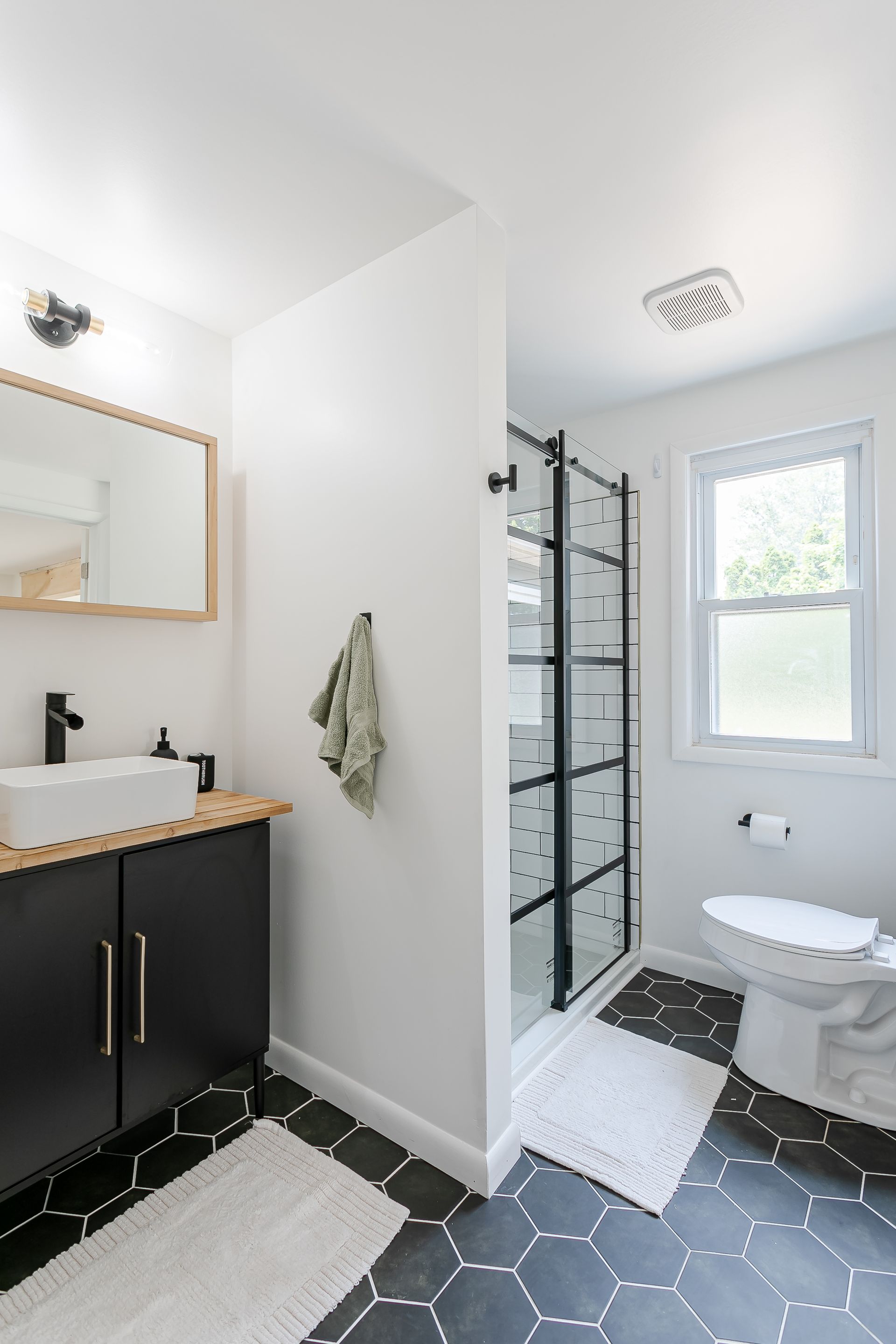 A bathroom with a toilet , sink , and shower.