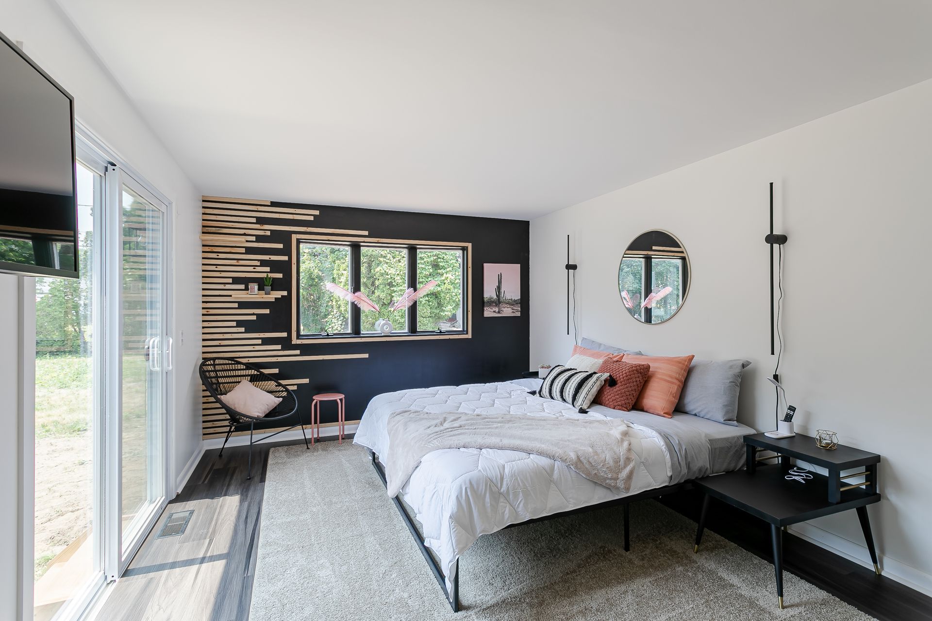A bedroom with two beds , a television and a sliding glass door.