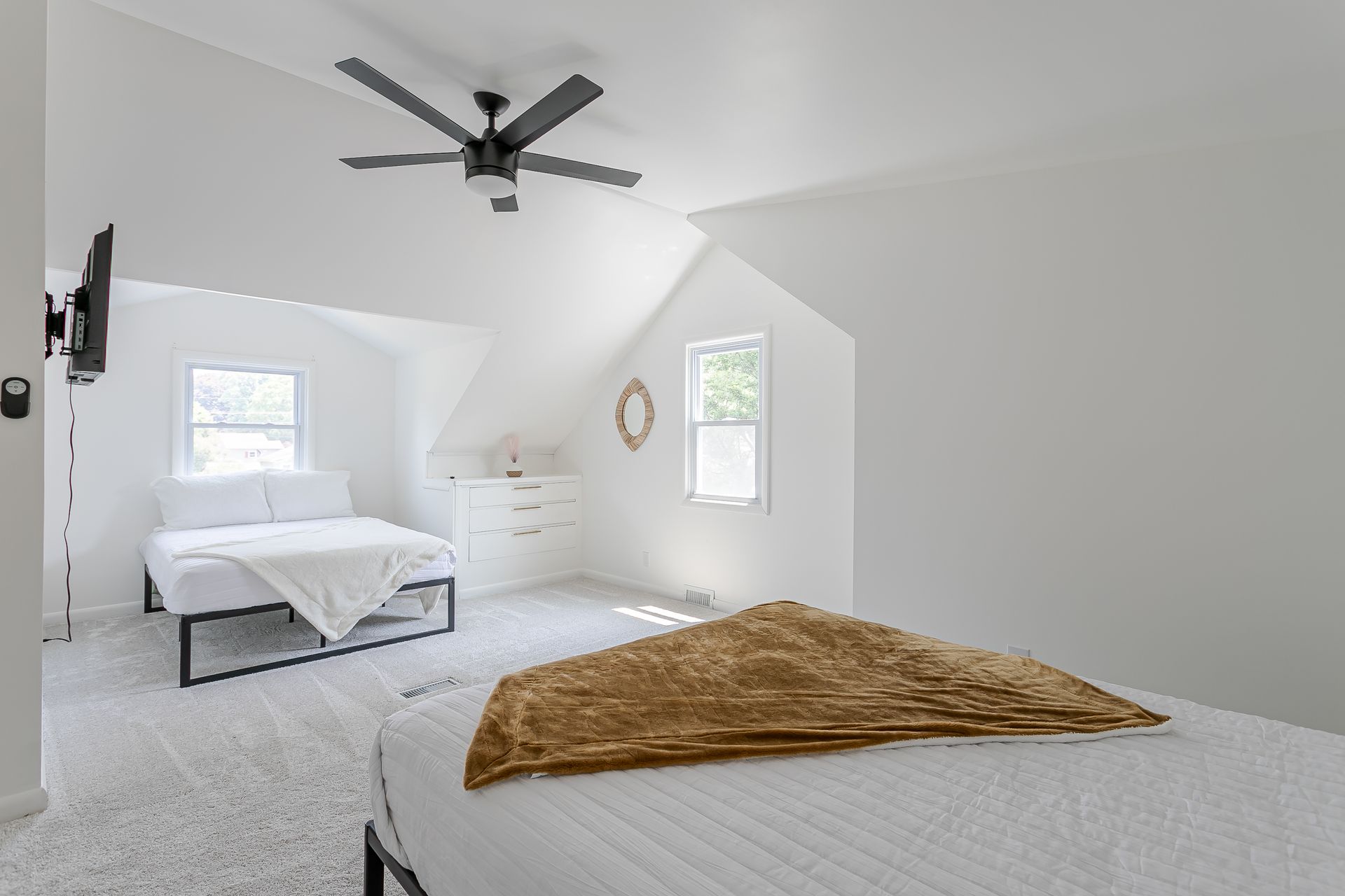 A bedroom with a bed and a ceiling fan.