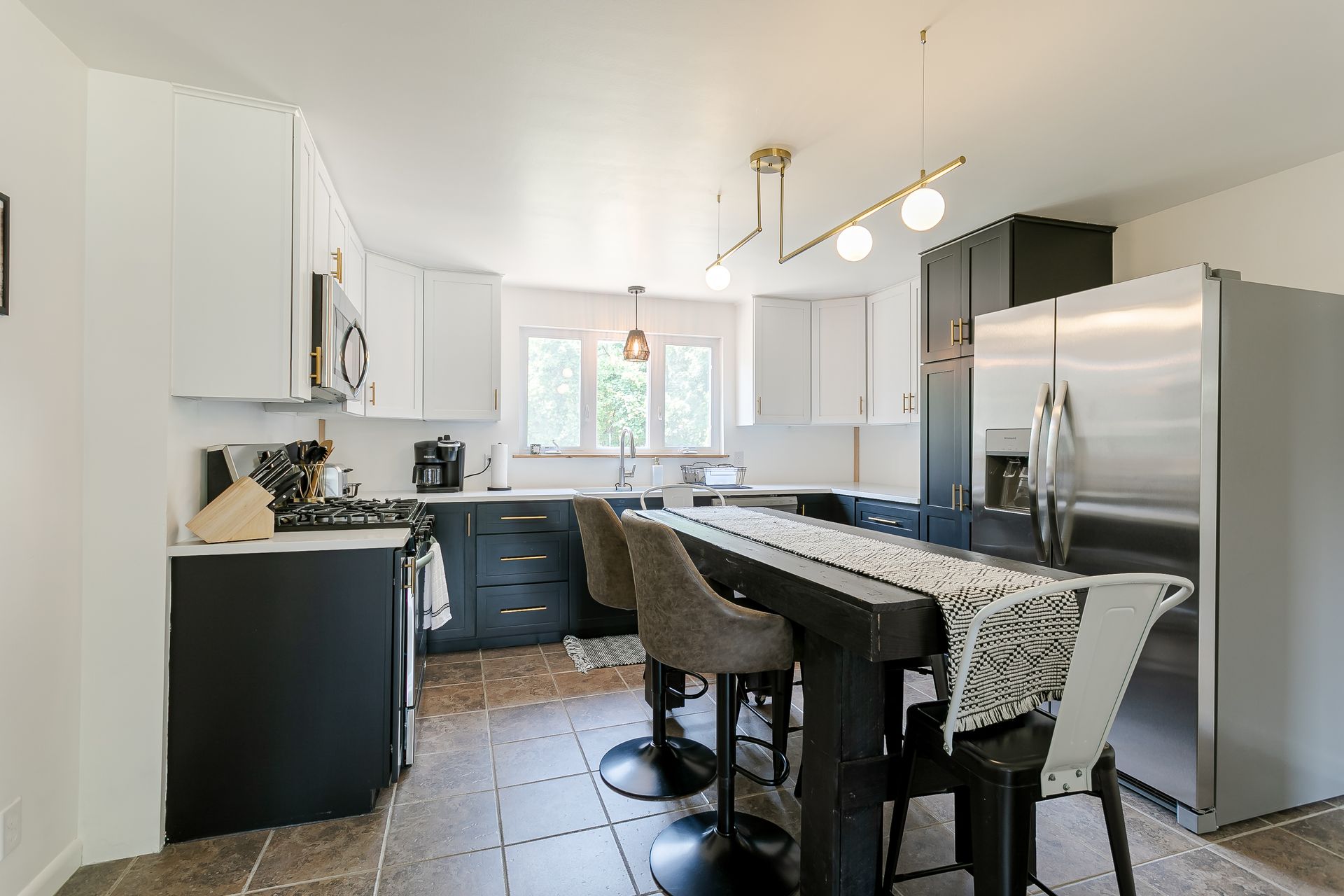 A kitchen with a table and chairs and a refrigerator.