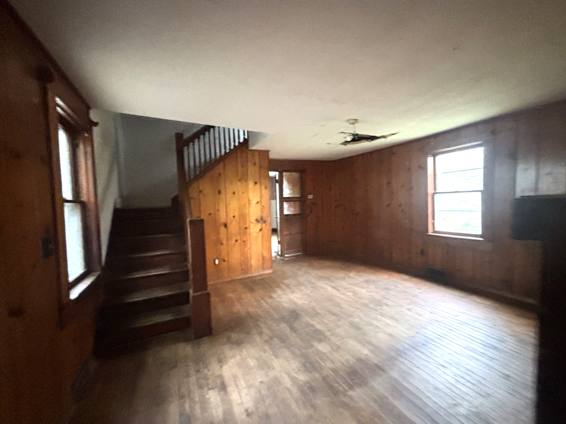 An empty living room with hardwood floors and a fireplace.
