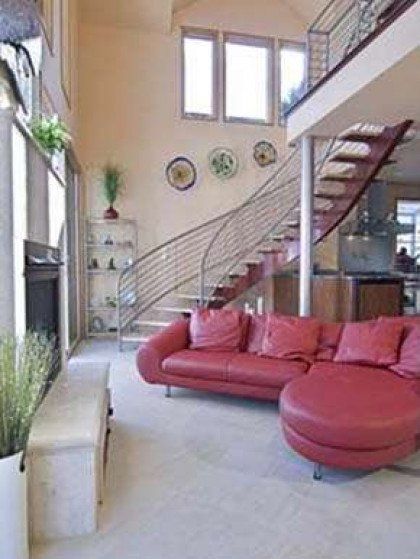 A living room with a red couch and stairs
