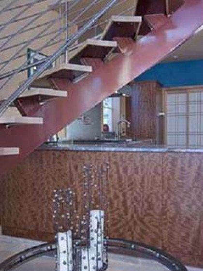 A wooden staircase in a room with a glass table in front of it