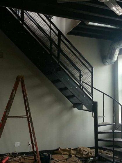 A ladder is sitting next to a staircase in a room