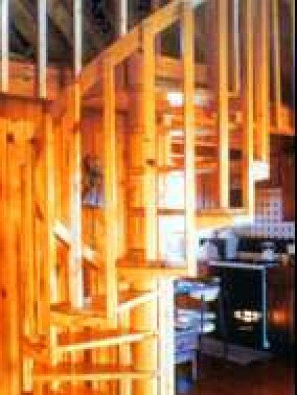 A wooden spiral staircase leading up to the second floor of a house.
