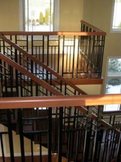 A staircase with a wooden railing and a metal railing