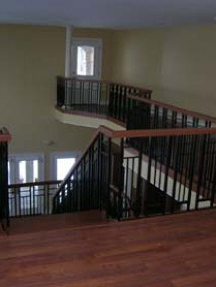 A staircase with a wooden floor and a metal railing